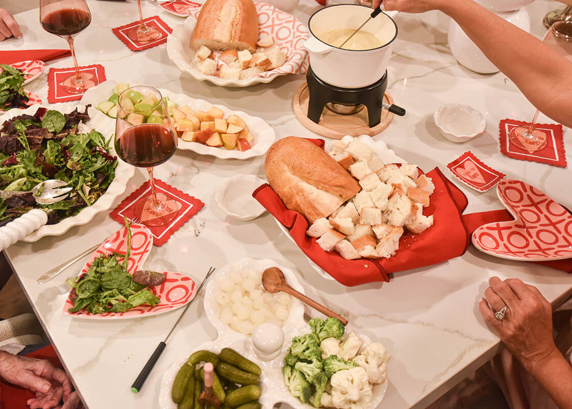 Overhead View of People Enjoying a Fondue Valentine's Dinner with Signature White Ruffle Three Bowl Server