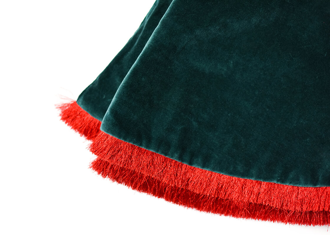 Cropped Close up of Folded Pine Velvet Tree Skirt with Trim Showcasing Red Fringe Trim and Soft Texture of Fabric