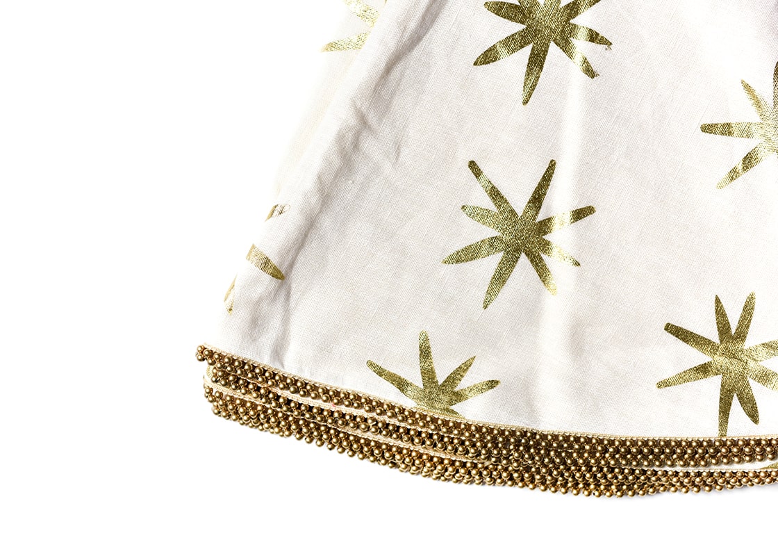 Cropped Close up of Folded Gold Stars Tree Skirt with Beaded Trim Showcasing Unique Trim and Beautiful Texture of Fabric