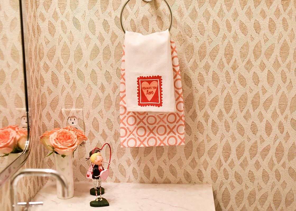 Front View of Layered Valentine Hand Towels Including Stamp of Love Medium Hand Towel Hanging in Powder Room