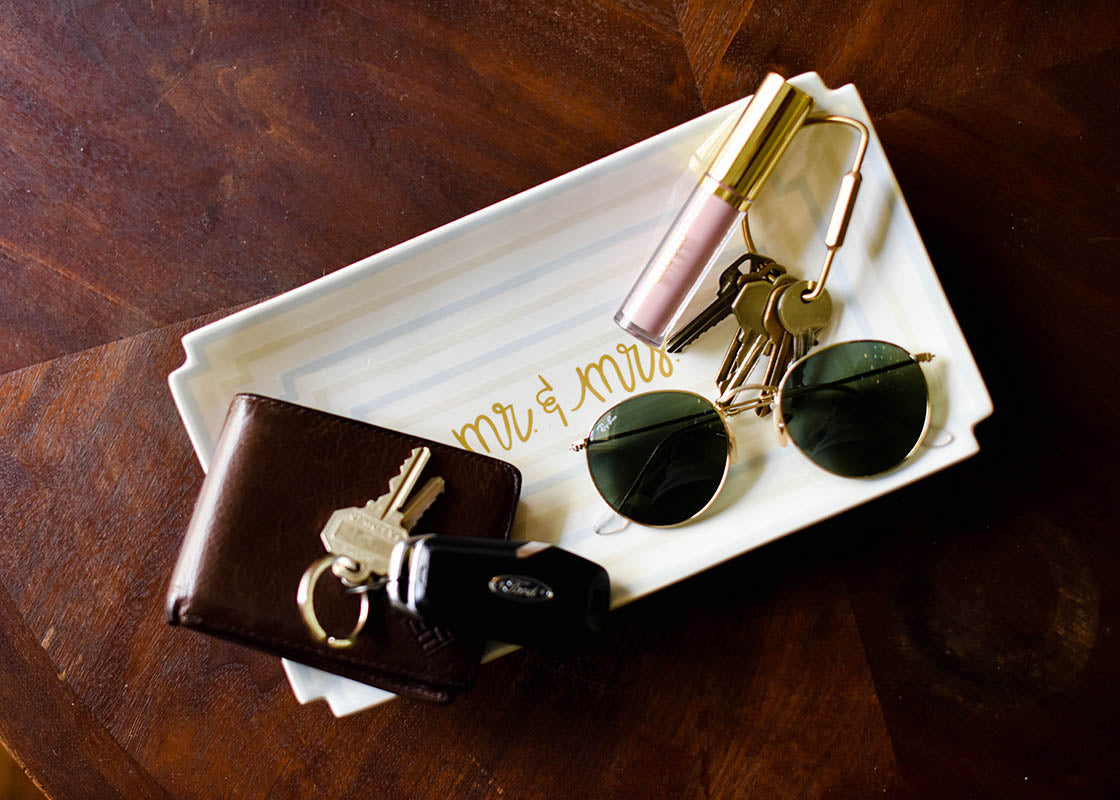 Overhead View of Celebratory Catch-all Ecru Mr. and Mrs. Notch Tray with items Including Keys, Sunglasses and Lipstick